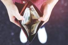 person opening a wallet with money in it